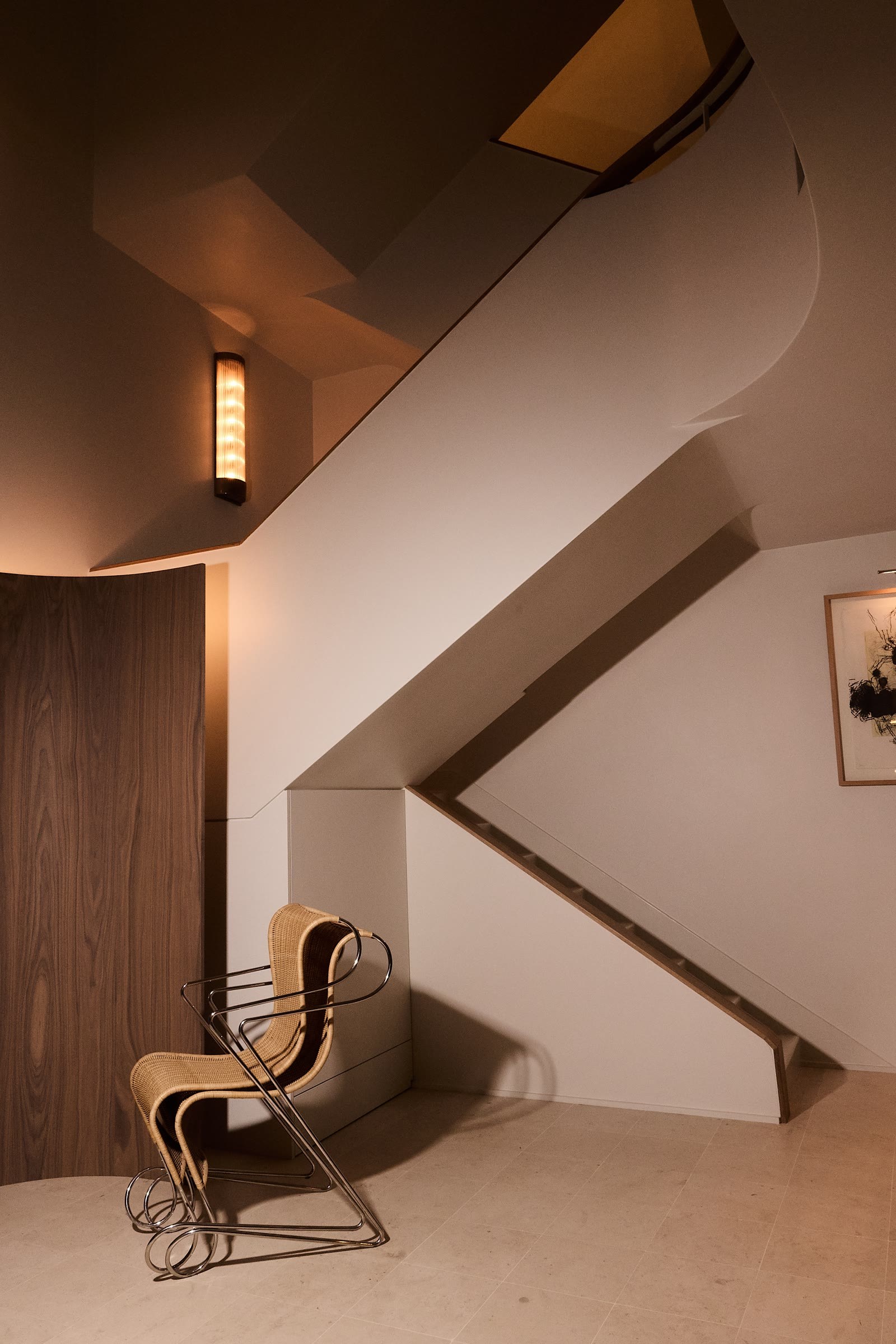 Escalier, globe lumineux et fauteuil en rotin