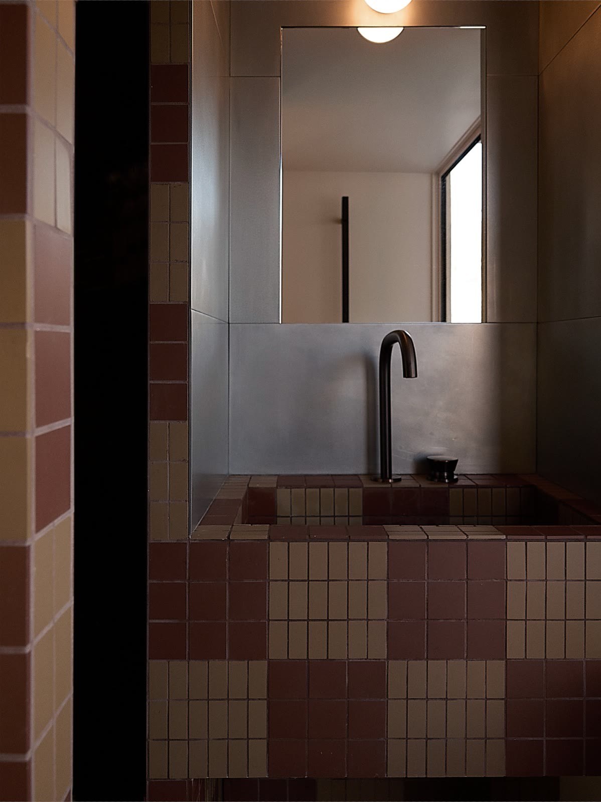 Salle de bains, damier de carreaux bordeaux et robinetterie noire